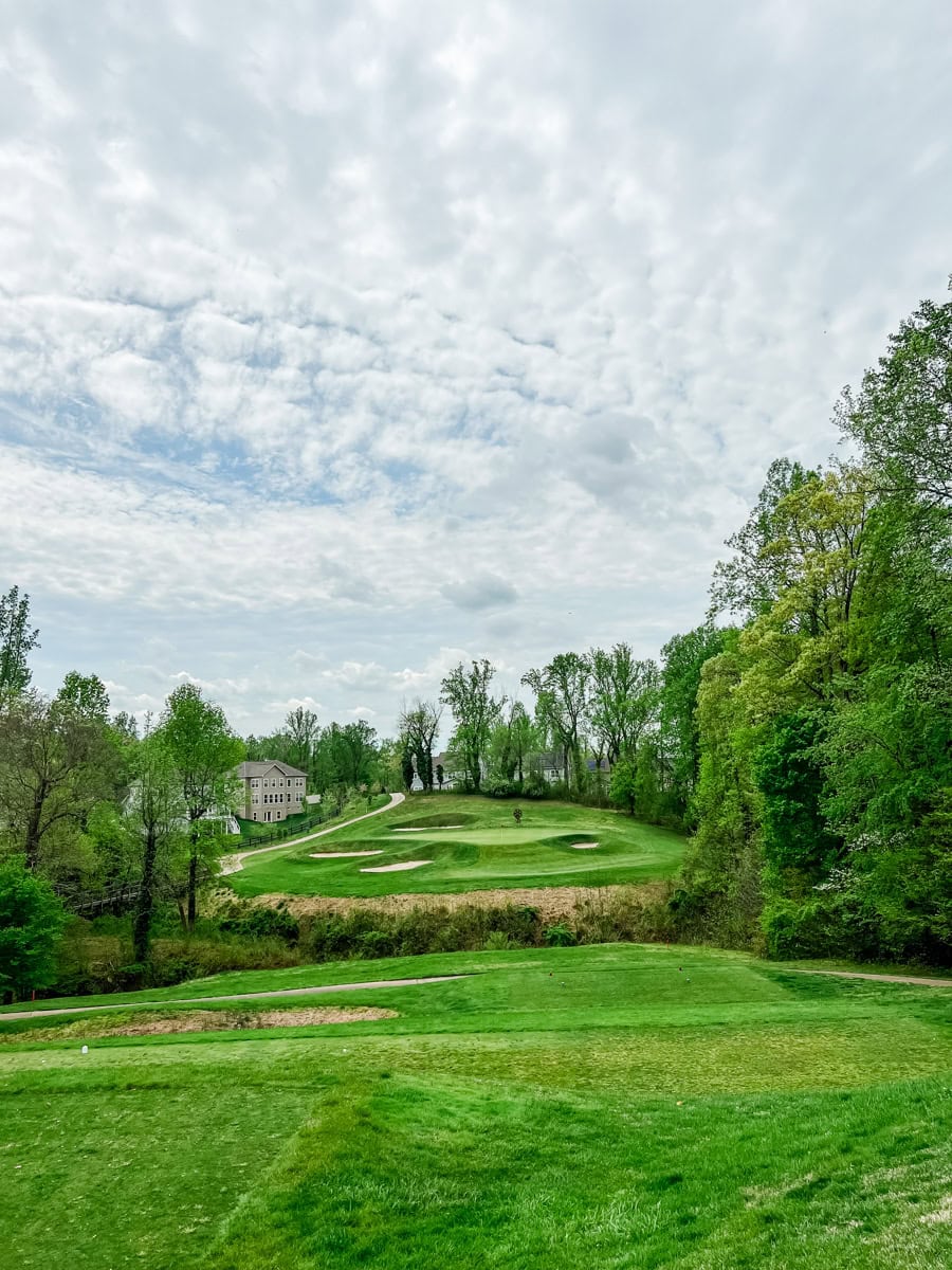 from the tee box looking at the green protected by four bunkers on a par 3 during a cloudy day in early Fall